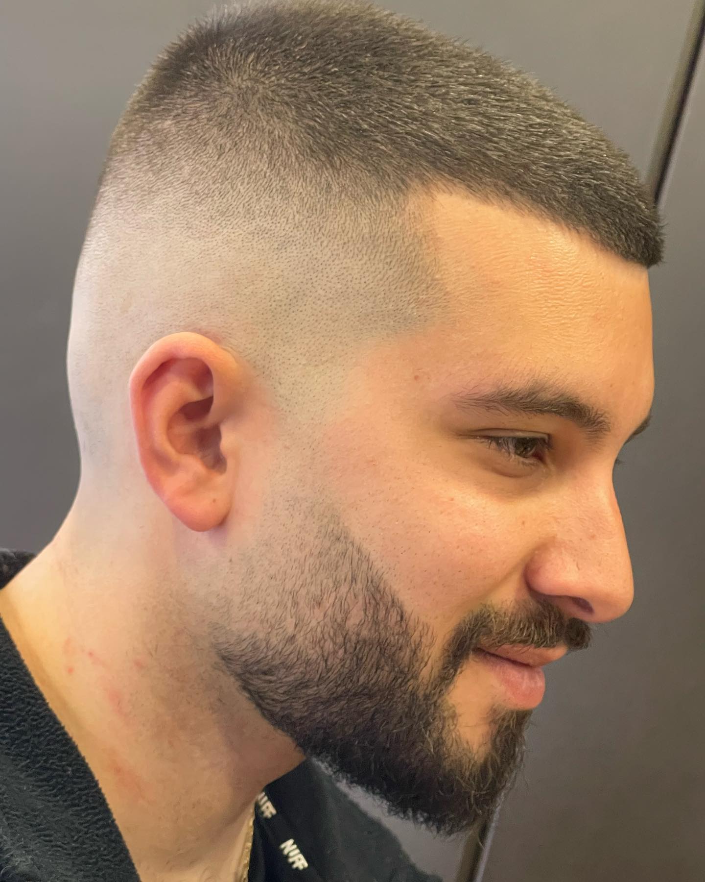 Buzz cut with clean skin fade and shaped beard