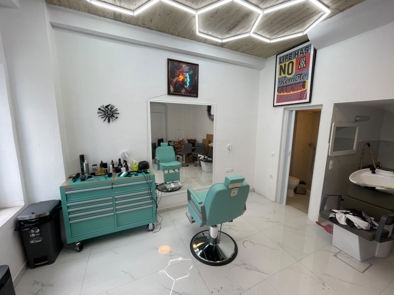 Turquoise barber chair and geometric lighting inside Bengu Hair Studio